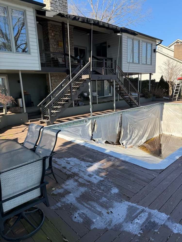 The same kind of project before renovation — torn vinyl liner and worn deck