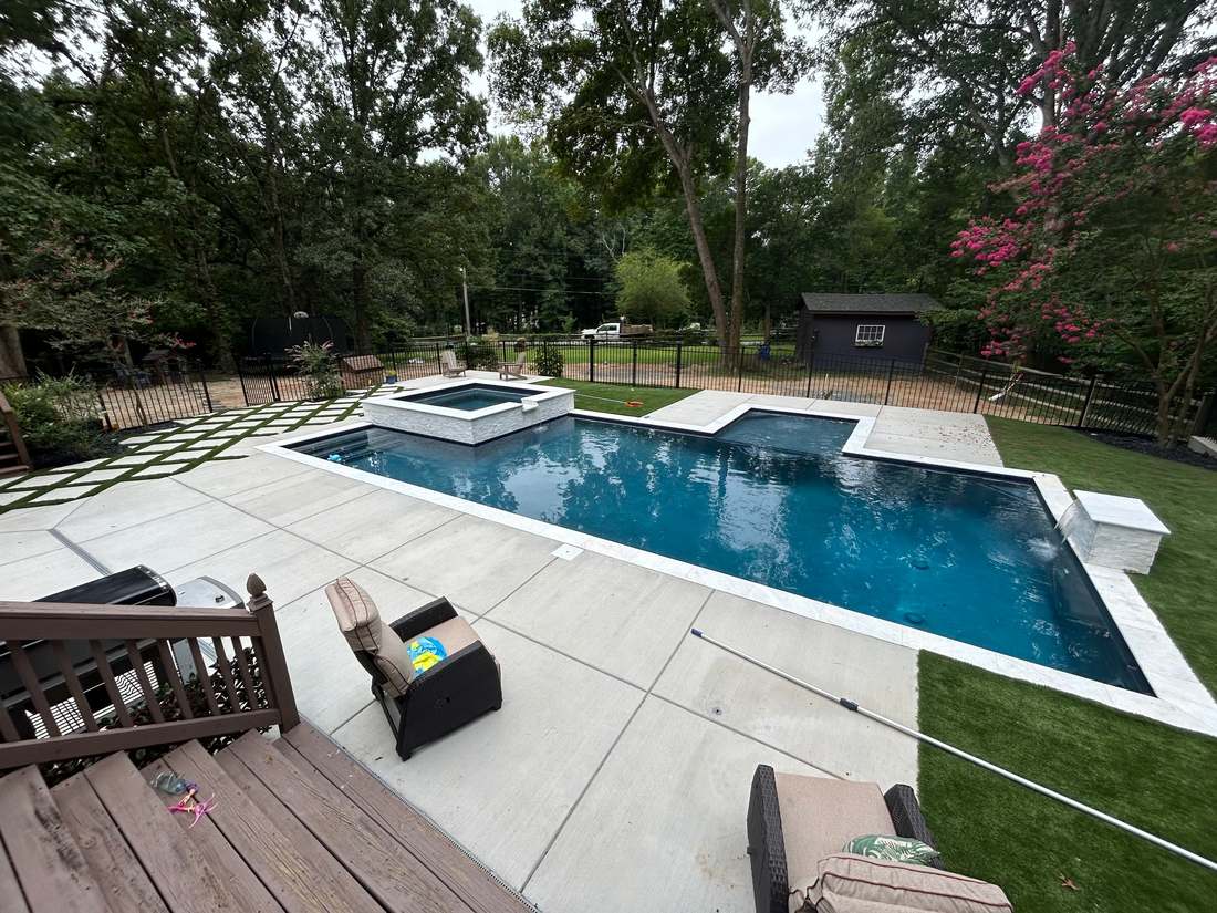 Renovated pool with sheer-descent waterfall and crepe myrtle blossoms on the deck