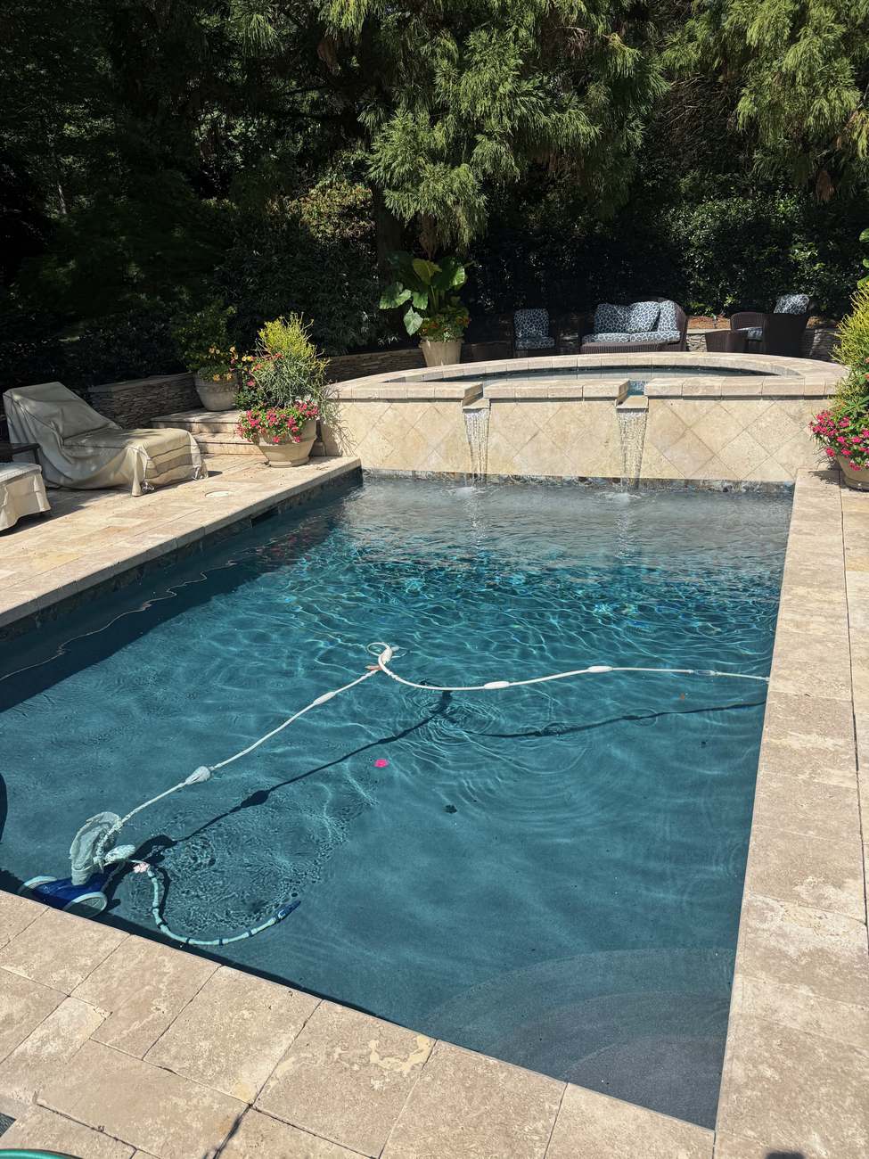 Travertine pool with twin waterfall spillways from a raised spa